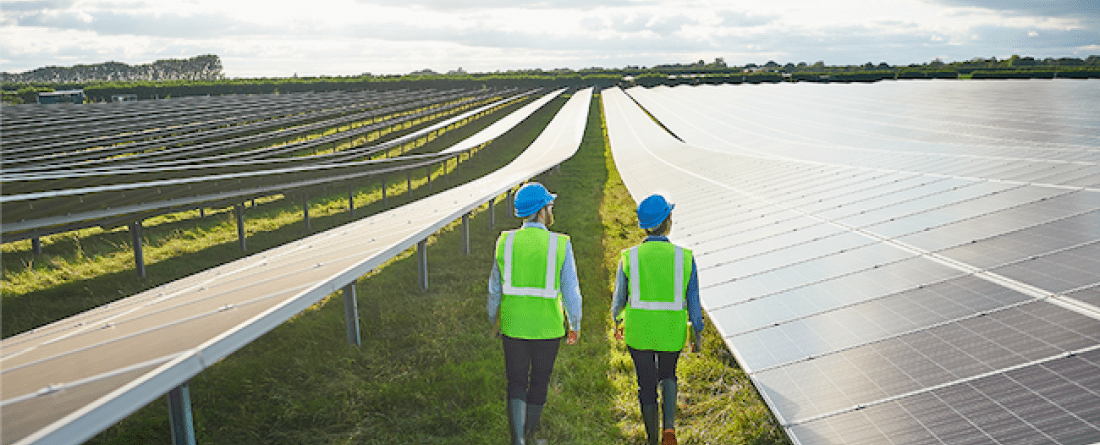 Two people near solar panels