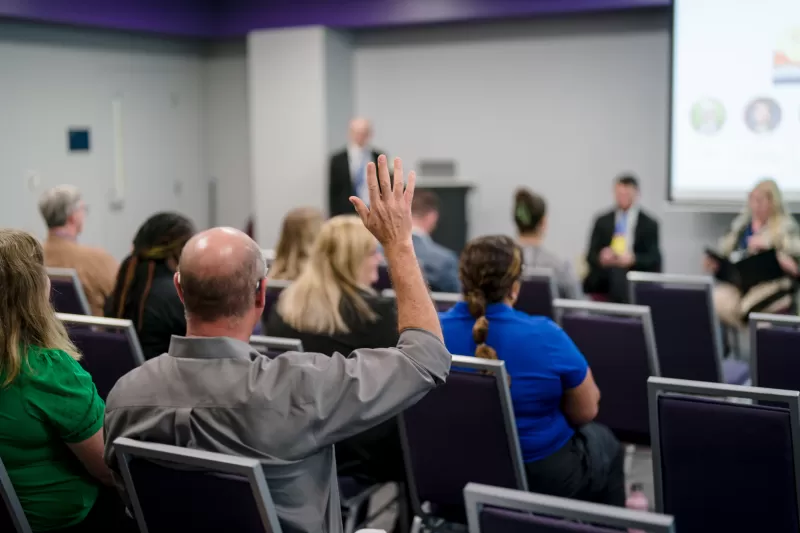 man raises his hand in clean energy workshop