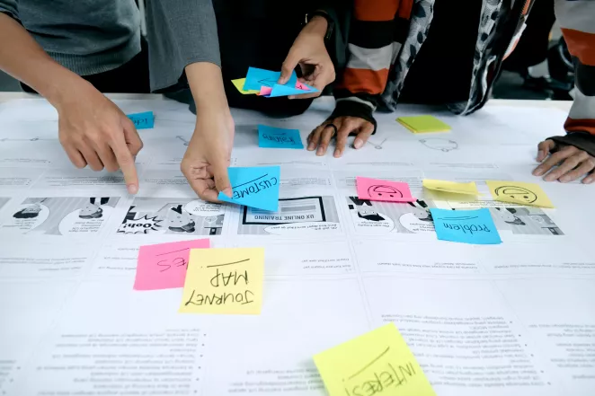 Image of hands organizing notes on a research board